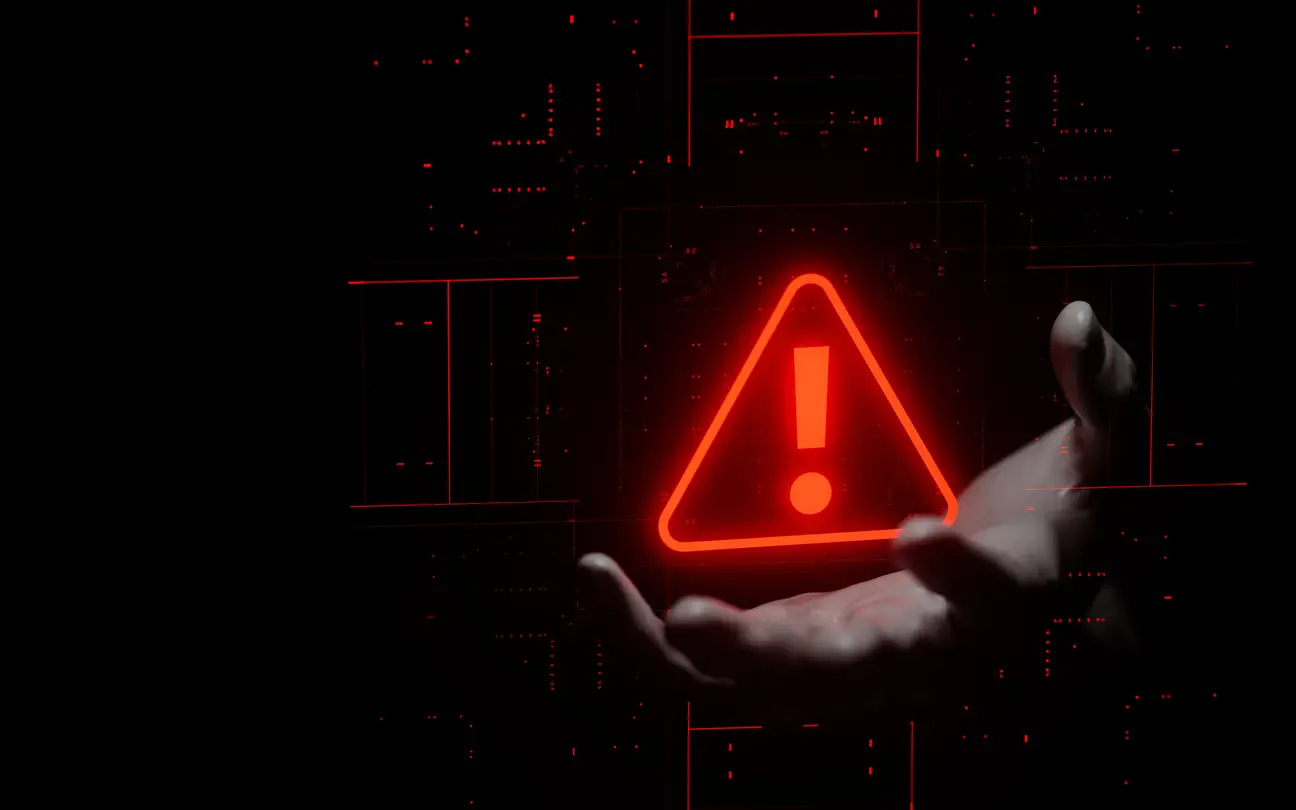 Hand holding a glowing red warning sign.