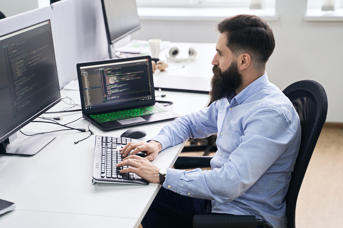 An IT support employee running diagnostics on a laptop computer.