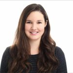 Smiling woman with long, dark hair, wearing a striped top, against a bright white background.