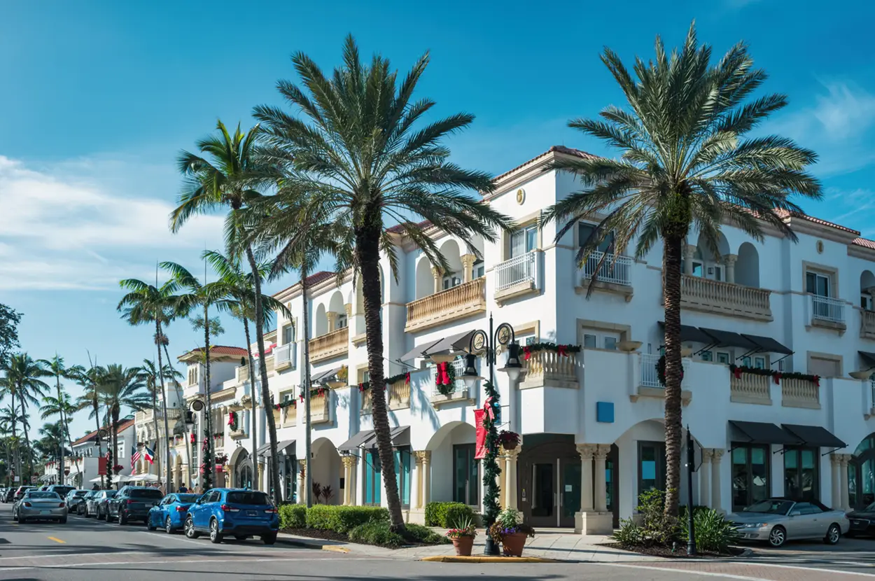 Charming street view of Naples shopping district lined with palm trees and festive decorations.