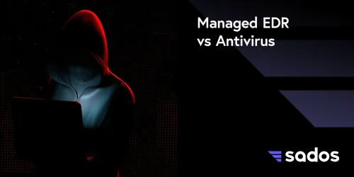 Silhouette of a hooded figure using a laptop, highlighting Managed EDR vs Antivirus cybersecurity solutions.
