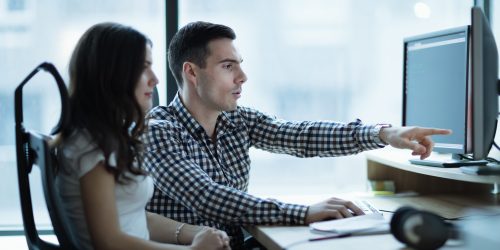 Colleagues developing software together in office