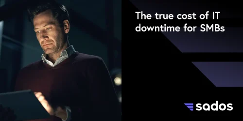 Man analyzing data on a tablet in a dark setting, emphasizing the impact of IT downtime on SMBs.